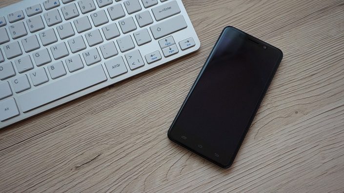 LaptopSmartphone Ein Smartphone und ein Laptop liegen auf dem Tisch.